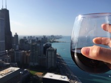 Cropped Image Of Woman Holding Wineglass Against City