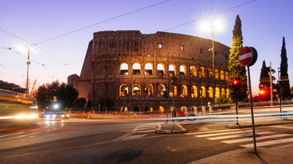 Wall Mural - Rome, Italy - Jan 2, 2020: Colosseum at night with colorful blurred traffic lights