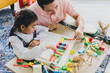 © Nawarit - Asian father and daughter play a jigsaw on the table in the words 'Love.' In the living room decorated with Christmas trees to prepare to celebrate Christmas and New Year.