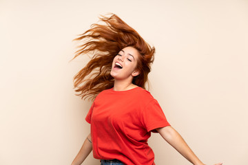 Teenager redhead girl dancing over isolated background