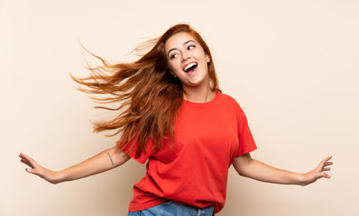 teenager redhead girl dancing over isolated background
