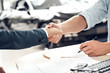 © Viktoriia - Businessman and clients shaking hands in auto salon