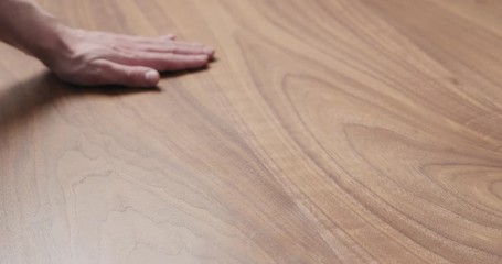 Sticker - Slow motion man hand touches black walnut dining table surface