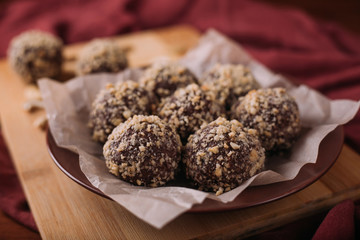 Wall Mural - Cocoa balls, chocolate truffles cakes on board on wooden background