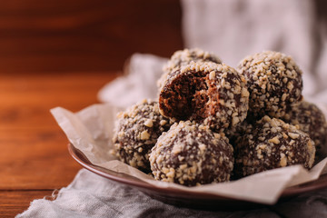 Wall Mural - Cocoa balls, chocolate truffles cakes on board on wooden background