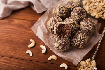 Wall Mural - Cocoa balls, chocolate truffles cakes on board on wooden background