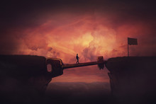 Conceptual View, Businessman Crosses A Chasm Obstacle Balancing On A Huge, Golden Key Shaped Bridge. Way To Success Concept, Reach The Finish Flag. Achieve Goal Metaphor. Mixed Media, Sunset Sky Scene