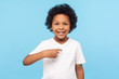 © khosrork - This is me. Portrait of happy preschool curly boy in T-shirt joyfully looking at camera and pointing to himself, proud of own success, egoistic child. indoor studio shot isolated on blue background