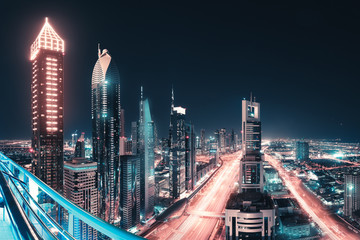 Wall Mural - Night view of the spectacular landscape of Dubai with high-rises and skyscrapers at the Sheikh Zayed highway. Global travel destinations and real estate concept