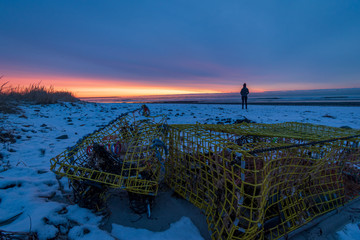 Wall Mural - Winter sunrise on Drakes Island Beach, Maine with person silhouette.