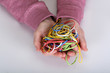 Many colored elastic bands in the hands