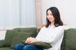 © garage38 - リビングのソファーに座る女性