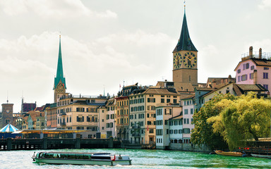 Canvas Print - River cruiser at Limmat quay and Saint Peter Church and Fraumunster Church in the city center of Zurich, Switzerland.