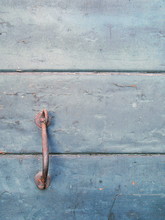 Close-up Of Rusty Handle On Weathered Wooden Door