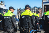 Fototapeta  - Dutch police squad formation and horseback riding mounted police back view with 