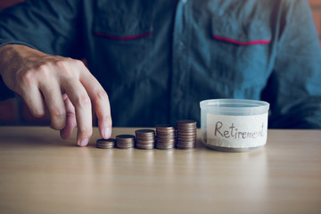 Wall Mural - Men are holding coins dropping to the money box with the concept of saving.