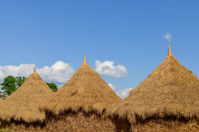 Thatched Roof Huts Against Sky