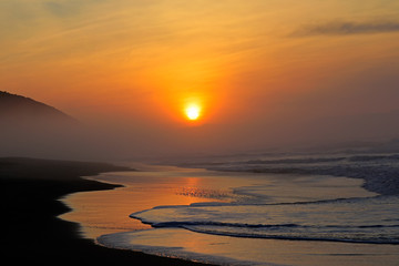 Poster - Seascape at sunrise with warm colors and reflections from the early morning sun, South Africa.