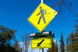 Pedestrian crossing sign with flashing lights during day time. Crosswalk beacon provides advance notice of pedestrian activity for drivers