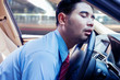 Businessman sleeping on the steering wheel