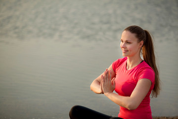 Sticker - beautiful young woman in sportswear in summer yoga pose in a park near a lake