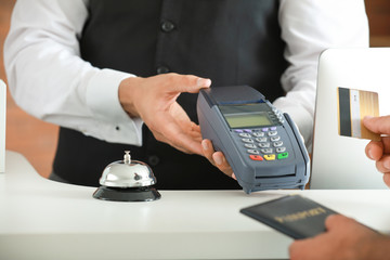 Man paying for hotel room at reception, closeup