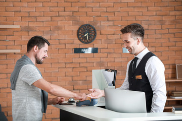 Poster - Man paying for hotel room at reception