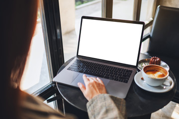 Mockup image of a woman using and touching on laptop computer touchpad with blank white desktop screen in cafe