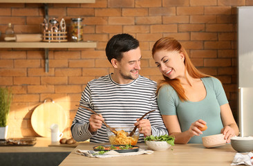 Happy couple cooking together in kitchen