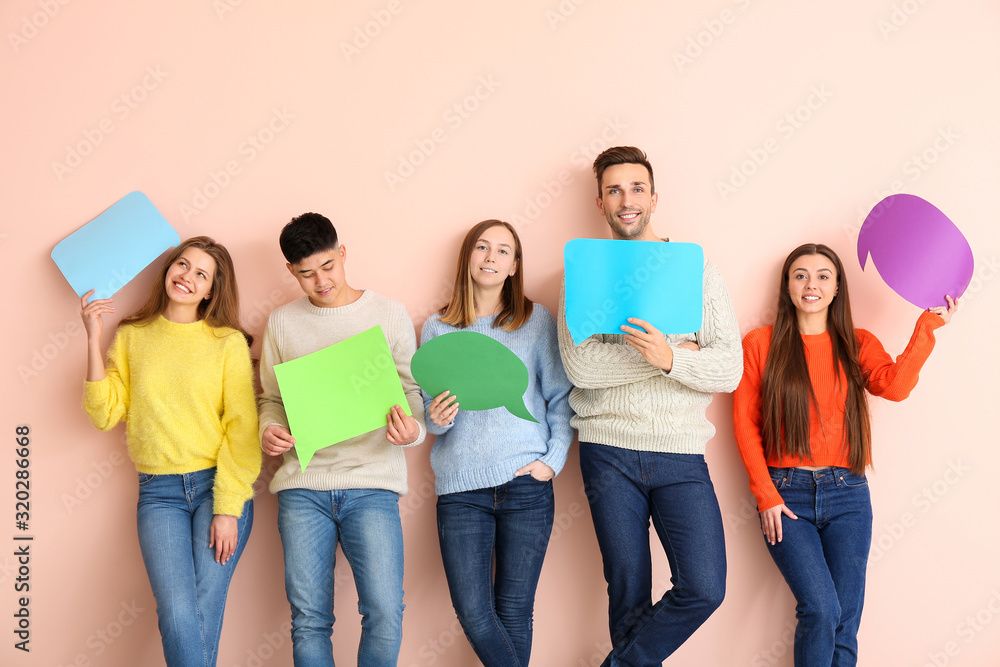 Group of young people with blank speech bubbles on color background