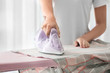 © Pixel-Shot - Woman ironing clothes at home