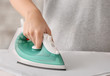 © Pixel-Shot - Woman ironing clothes at home, closeup