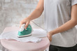 © Pixel-Shot - Woman ironing clothes at home