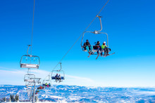 Skiers On Chairlift At Mountain Ski Resort With Beautiful Winter Landscape In The Background
