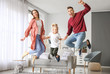 © Pixel-Shot - Happy family jumping at home