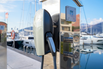 January 13, 2020, Tivat, Montenegro: Charging station (EV) for ecological Tesla vehicles or beach marina  as a background, with white yachts in blue sea.