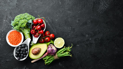Wall Mural - Fresh vegetables and fruits on a black background. Vitamins and minerals. Top view. Free space for your text.