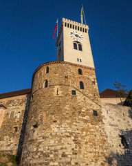 Clocktower with Slovenian flag in Ljubljana castle, blue sky background