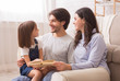 © Prostock-studio - Little girl reading book with her parents at home