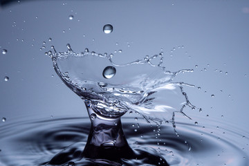 Wall Mural - water drops collision on a blue background. abstract clear nature background