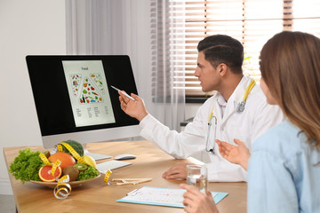 Wall Mural - Nutritionist consulting patient at table in clinic