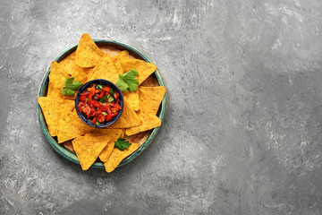 Wall Mural - Salsa sauce and nachos on a plate, gray concrete stone background. Traditional latin american appetizer. Top view, flat lay.