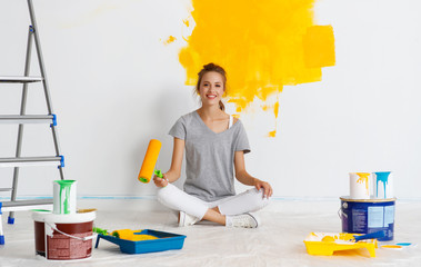 Wall Mural - Repair in apartment. Happy young woman paints wall .