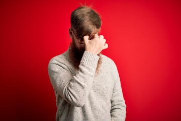 Sticker - Handsome Irish redhead man with beard wearing casual sweater and glasses over red background tired rubbing nose and eyes feeling fatigue and headache. Stress and frustration concept.