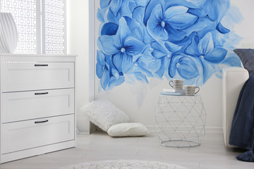 Sticker - Stylish living room with blue flowers painted on wall. Floral pattern in interior design