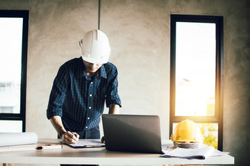 Wall Mural - engineer working on blue print and search on laptop in construction site