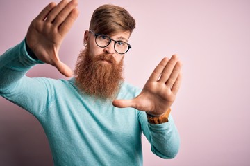 Sticker - Handsome Irish redhead man with beard wearing glasses over pink isolated background doing frame using hands palms and fingers, camera perspective