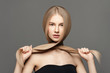 © Beauty Agent Studio - Hair care. Hair cut.Beautiful young woman with long healthy hair posing against grey background. Beauty salon concept