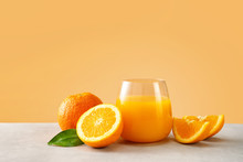 Close Up Of Orange Juice In A Glass With Oranges Against Trendy Yellow Background