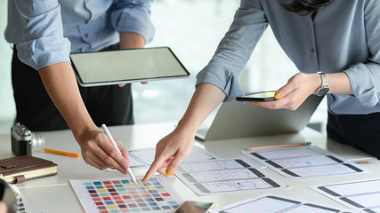 The UX design team with tablet plans to develop a prototype smartphone application.